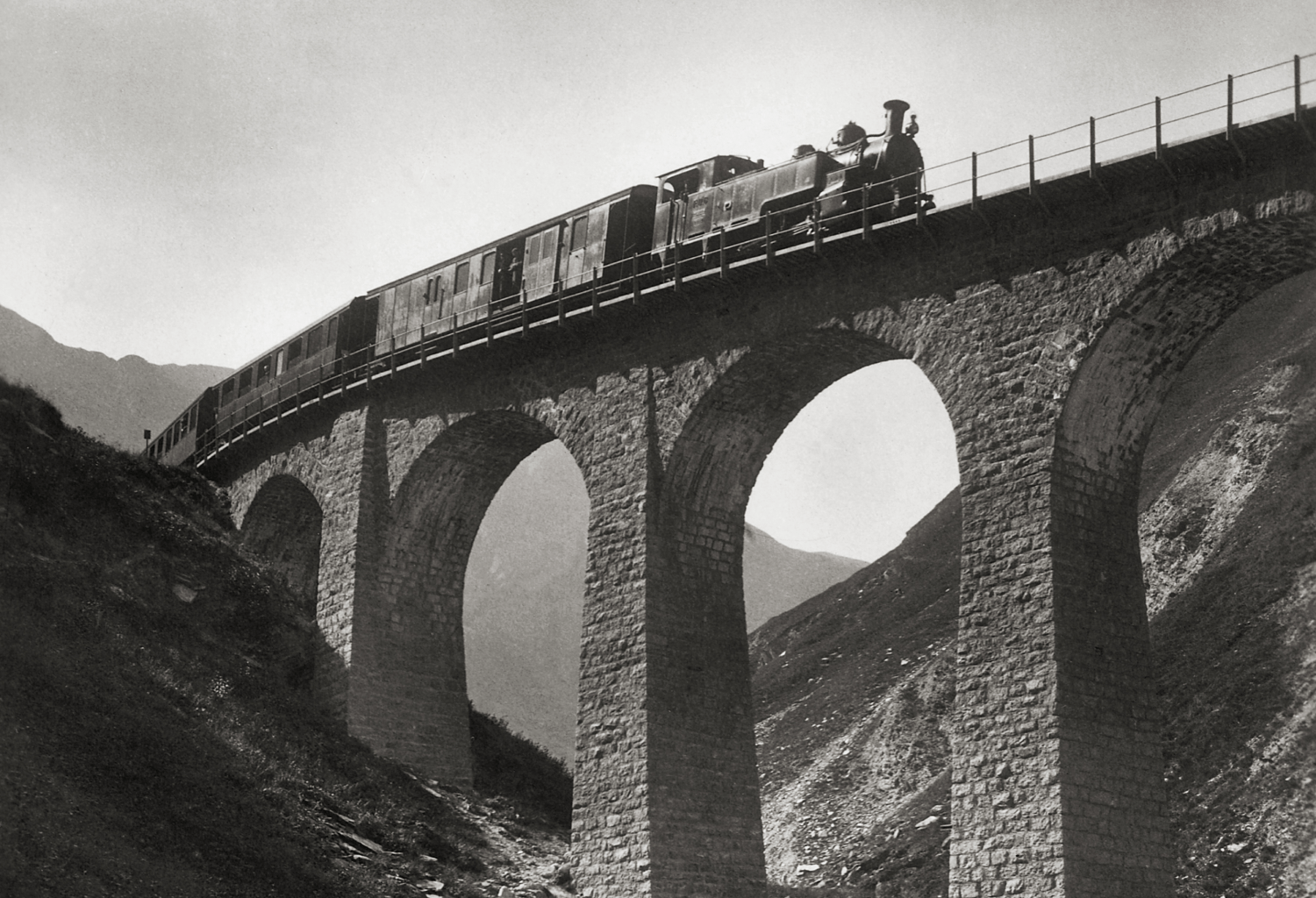 Historical image of the stone bridge between the mountains on which the Glacier Express passes.