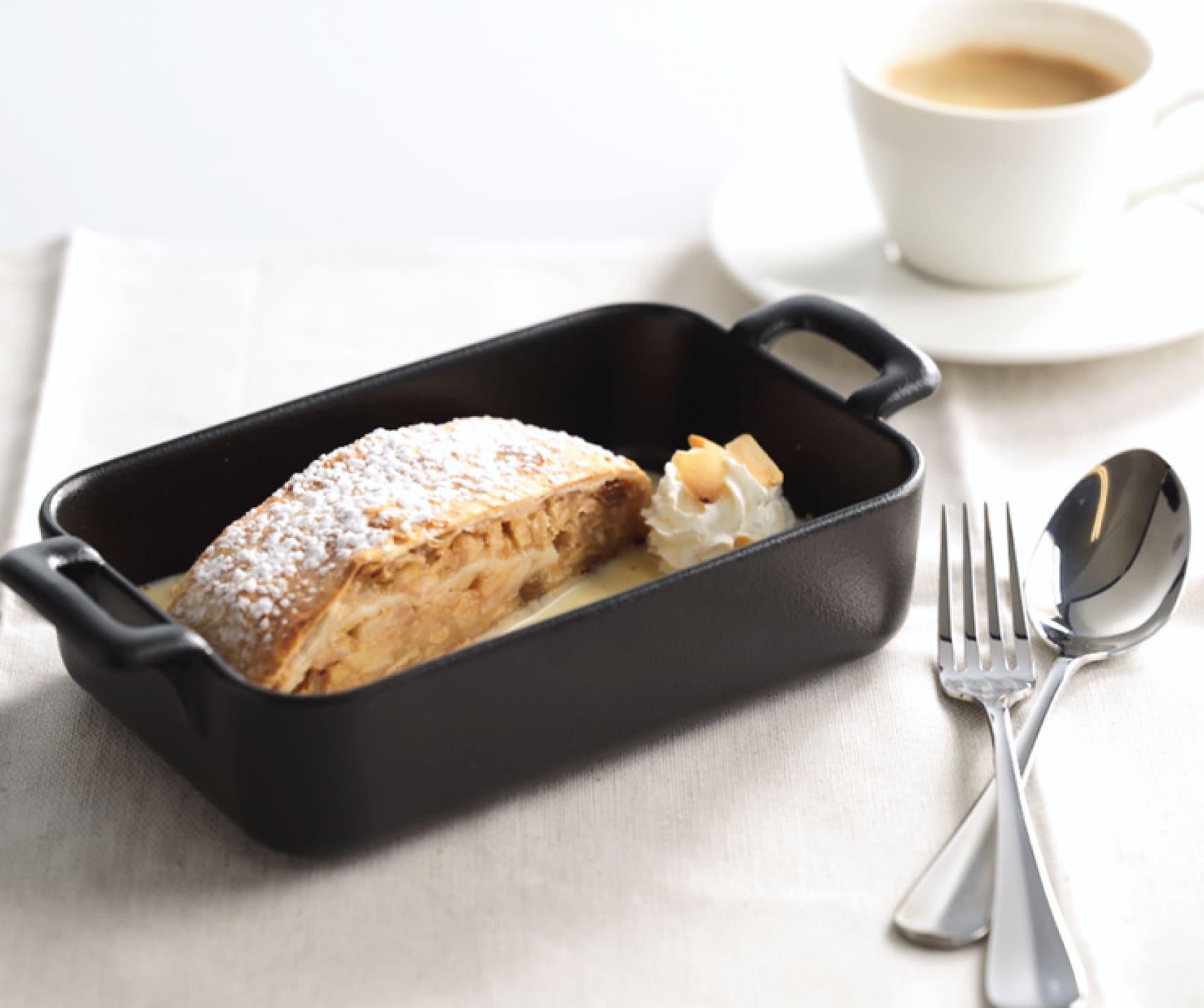 The image shows strudel with coffee in the background.