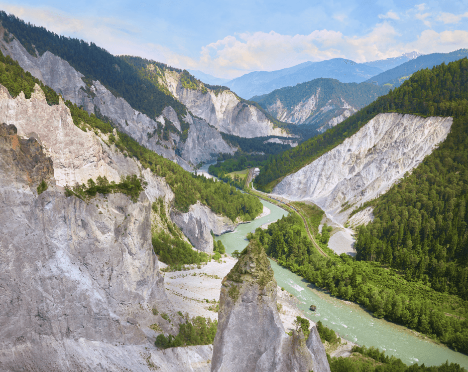 Auf dem Bild ist ein Fluss zu sehen, der sich durch eine felsige Berglandschaft schlängelt.