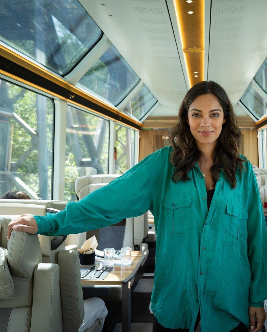 The image shows a young woman passenger on the Glacier Express train.